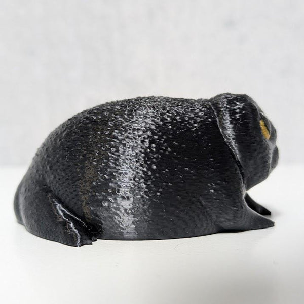 Side profile of the Depressed Dumpling™ figurine facing right, capturing its hunched pose and droopy vibe.