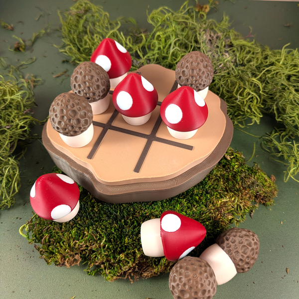 Overhead view of the mushroom tic tac toe set on a wood-textured surface, showing all 10 mushroom pieces and the log slice game board.