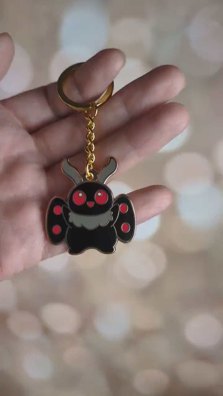 A video showing the cute mothman enamel keychain from all angles