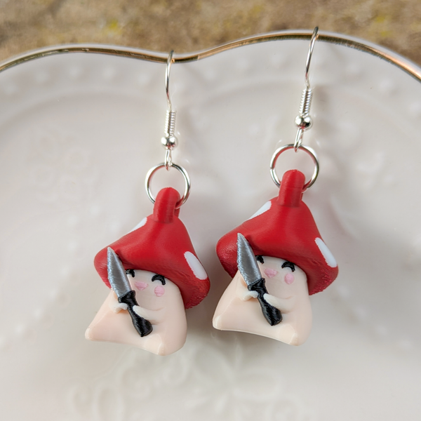 Close-up of Shroomshank mushroom earrings on white ceramic plate