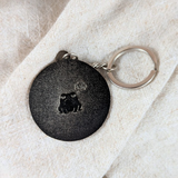 Back of possum keychain showing silver finish and engraved frog detail
